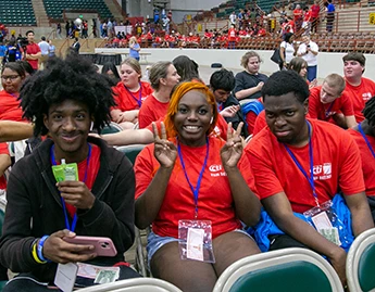 Group of kids sitting around a table in a conference hall