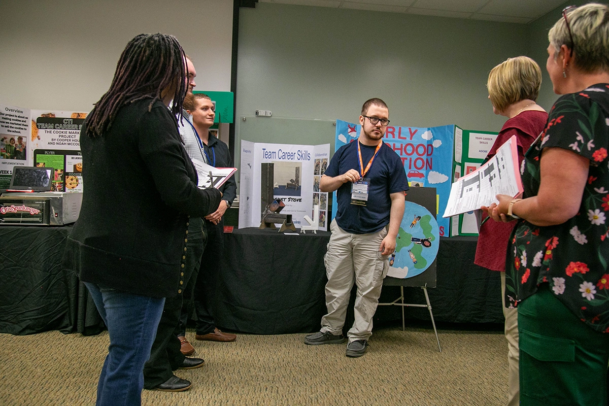 A student sharing his project with the judges at SLC